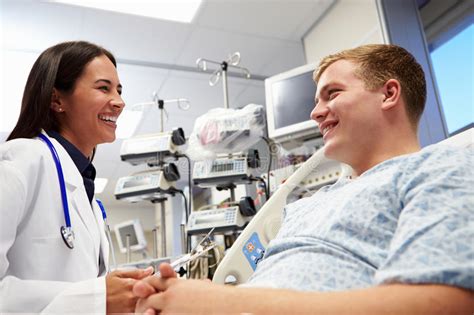 Young Male Patient With Female Doctor In Emergency Room Stock Image