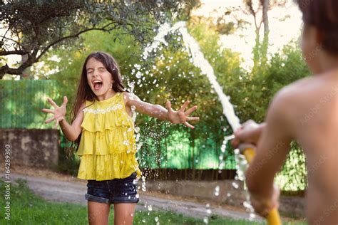 Screaming Girl Sprayed With Water Hose Stock Photo Adobe Stock