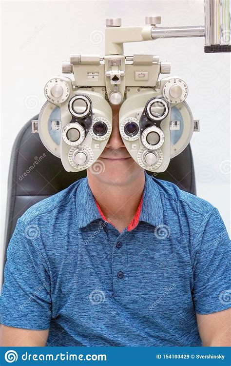 Optometrist Doing Sight Testing For Male Patient In Clinic Stock Image