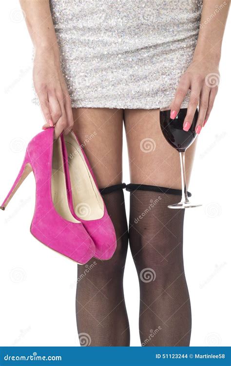 Young Woman Partying With Stocking Rolled Down Holding High Heels And