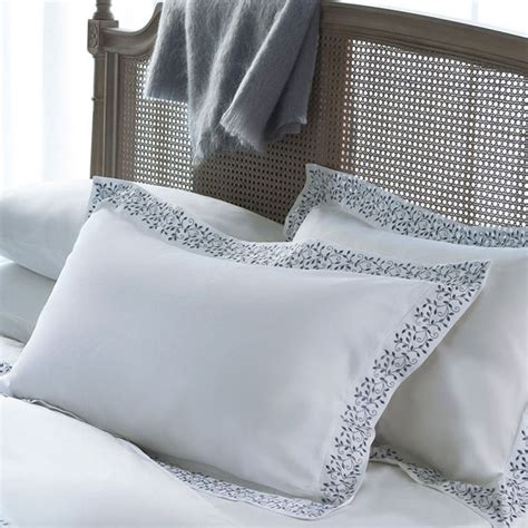 A Bed With White Sheets And Pillows On It