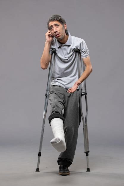 Free Photo Front View Young Male With Crutches Due To Broken Foot On