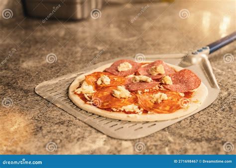 Pizza Maker Preparing The Typical Salami Pizza In The Italian Pizzeria
