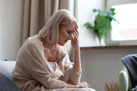 La Triste Femme Mature Assise Seule à La Maison Souffrant De Maux De Tête Photo Stock Image