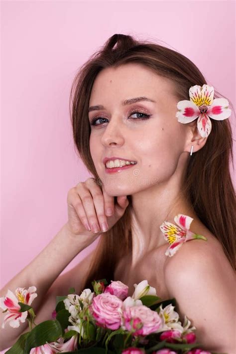 Naked Skinny Girl Holding Flowers On A Pink Background Brunette Stock