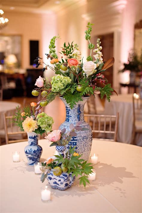 A Vase Filled With Flowers Sitting On Top Of A White Table Covered In