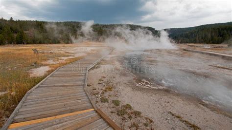 boardwalk curving around hot cascades hot spring in the lower geyser basin in yellowstone