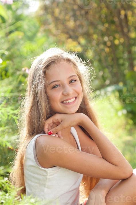 Portrait Of Pretty Teenage Girl Sitting Smiling Enjoying Nature