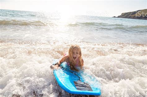 Girl Playing In Sea With Bodyboard On Summer Beach Vacation Stock Photo