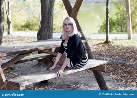 The Beautiful Blonde On A Bench In Park At The Lake Stock Photo Image Of Beauty Fashion