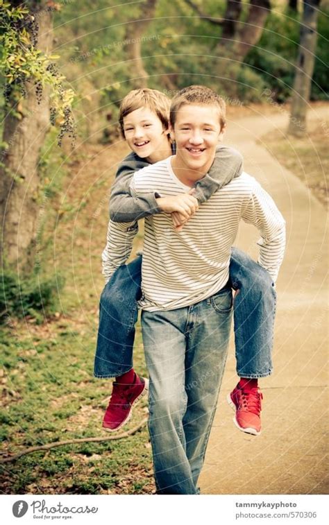 Older Brother Giving Piggyback To Younger Brother A Royalty Free