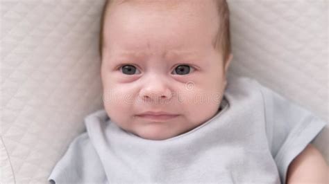Dissatisfied Crying Upset Sad Newborn Baby Boy Lying In Nursery
