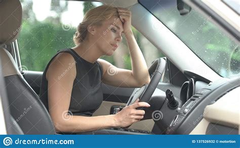 Depressed Female Driver Sitting In Car Thinking About Life Problems
