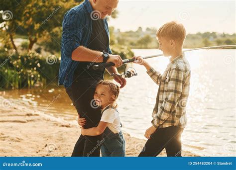 Padre Con Hijo E Hija Pescando Juntos Al Aire Libre En Verano Foto De