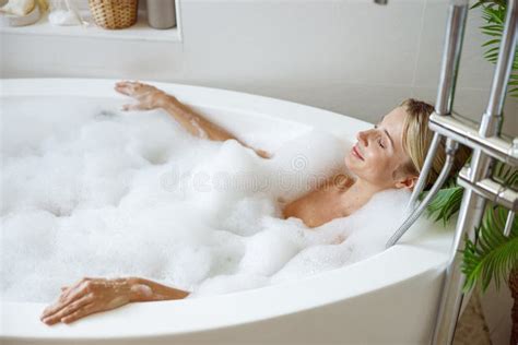 Top View On Young Blonde Attractive Female Lying In Hot Bathtub And
