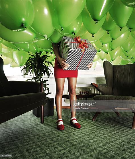 Girl Holding A Present In A Room Filled With Baloons Photo Getty Images