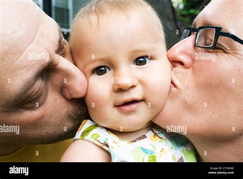Parents Kissing Their Baby Stock Photo Alamy