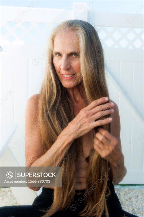 Partially Nude 57 Year Old Woman Pulling On Her Long Hair Smiling At