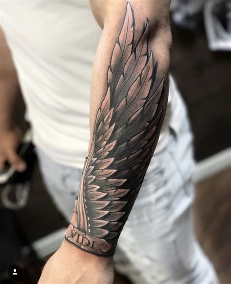 A Man S Arm With A Black And Grey Tattoo Design On The Left Arm
