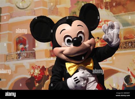An Entertainer Dressed In A Costume Of Micky Mouse Waves During A
