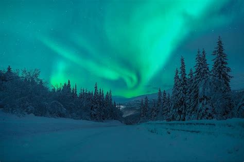 Aurora Borealis Over Mountain Road In Winter