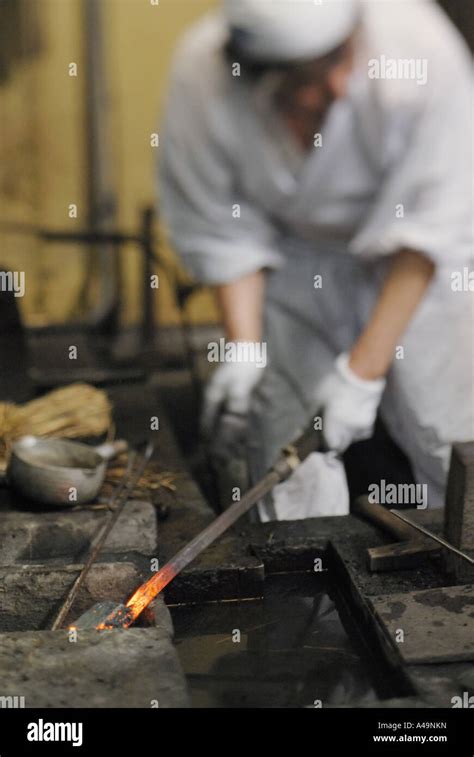 Blacksmith Holding A Heated Metal Rod Stock Photo Alamy