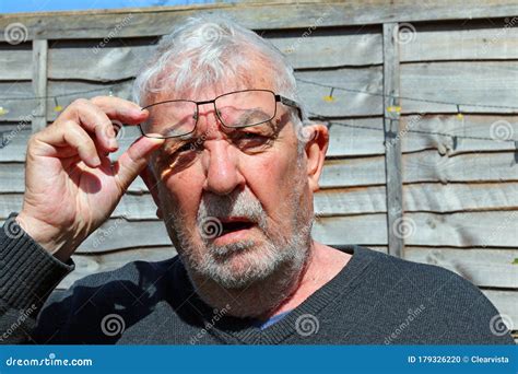 Senior Man Wearing Spectacles Glaring Towards Camera Stock Photo