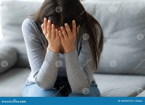 Unhappy Young Woman Covering Face With Hands Crying Alone Stock Photo