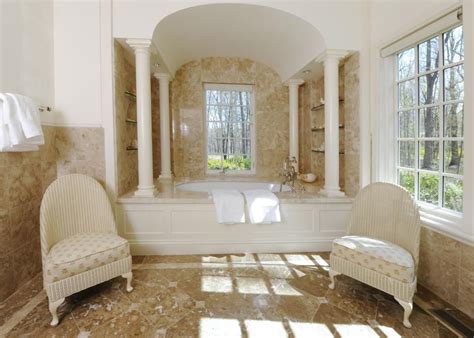 A Large Bathroom With Two Chairs And A Bathtub In Its Center Area