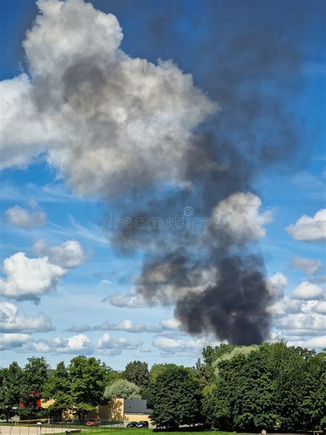 Black Smoke From The Fire Can Be Seen In The Distance Stock Photo