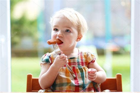 Funny Little Girl Eating Sausage From Fork Stock Photo By ©cromary 53877523