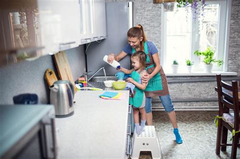 Madre E Hija En Casa En Los Platos Que Se Lavan De La Cocina Imagen De