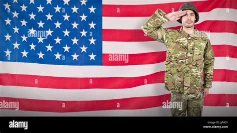 Portrait Of Confident Soldier Giving Salute Against Rippled Us Flag