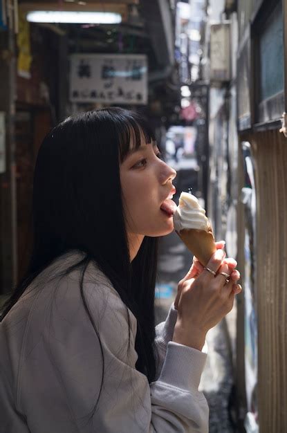 free photo side view woman licking ice cream cone