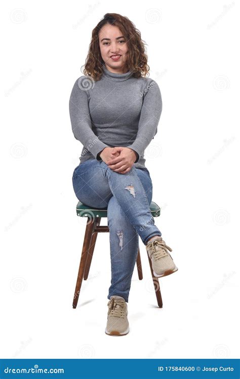 portrait of a woman sitting on a chair in white background looking at camera and arms stock