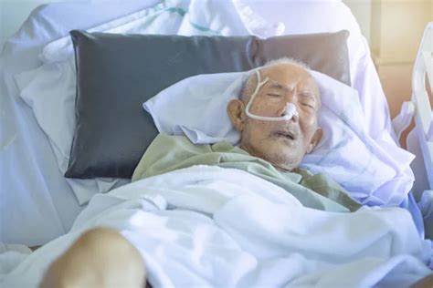 Asian Elder Man Sick And Have Tube In Hospital Ward Sleep In Coma State On Bed Stock Image