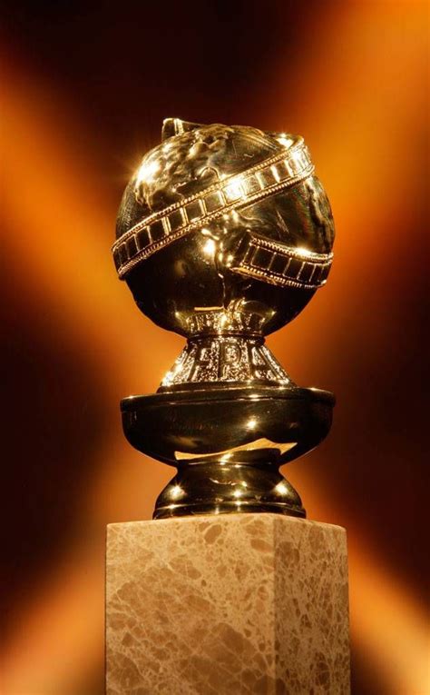 A Golden Globe On Top Of A Marble Block In Front Of A Brown Wall With