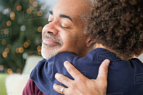 Mixed Race Grandfather And Grandson Hugging At Christmas Stock Photo