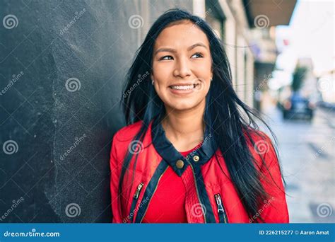 jovem latina sorrindo feliz inclinada na parede da cidade imagem de stock imagem de fundo