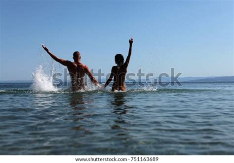 Sexy Couple In The Water Happy Couple Jumping On The Beach At Sunset Family Summer Holidays Or