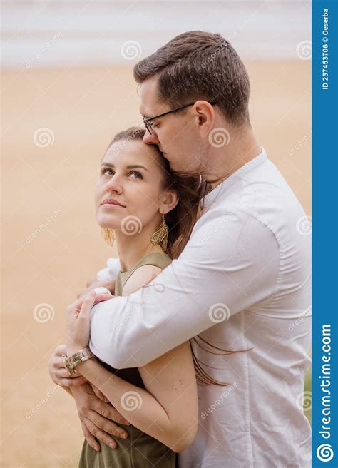 Portrait Of A Couple In Love A Man And A Woman Hugging Walking Along The Beach On The Sand On