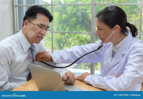 Doctor Using The Stethoscope Listen To Heartbeat Of Man Patient Stock