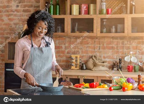 Cheerful Young Woman Cooking Healthy Food At Kitchen Stock Photo By
