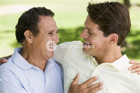 Two Men Standing Outdoors Bonding And Smiling Royalty Free Stock Image