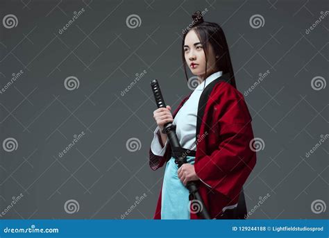 Young Asian Woman In Kimono Holding Katana And Looking Away Stock Photo