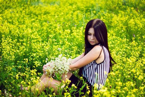 Beautiful Woman Sitting In Yellow Flower Field Background Stock Image