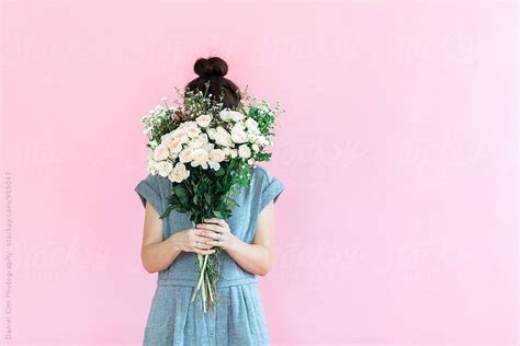 Girl Holding Flowers In Front Of Colorful Wall By Daniel Kim