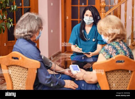 Female Doctor Using Sphygmomanometer Takes Blood Pressure Of Elderly