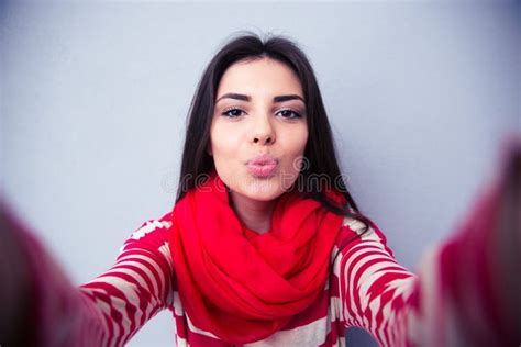 Beautiful Woman Kissing At Camera Over Gray Background Stock Image