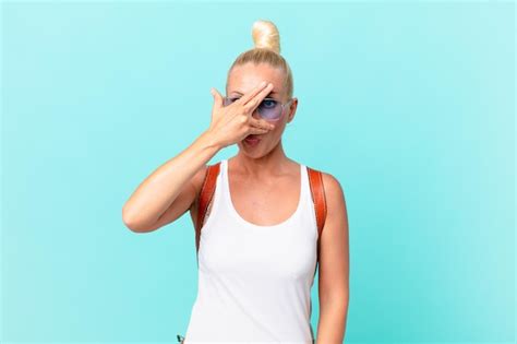 Premium Photo Pretty Blond Woman Looking Shocked Scared Or Terrified Covering Face With Hand